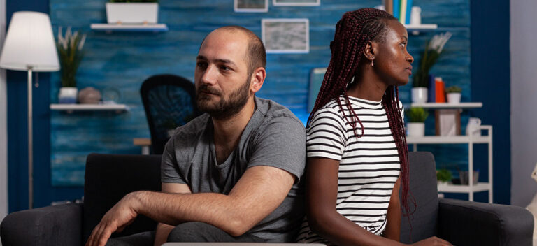 Couple looking away from each other considering discernment counseling to decide to stay or go